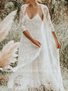 a woman in a white dress walking through tall grass