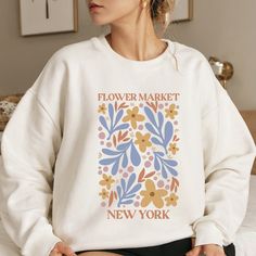 NY Flower Market Sweatshirt, Boho Cottagecore Crewneck, Botanical Floral Pullover, Oversized Wildflowers Sweatshirt, New York Sweatshirt  MATERIALS - Classic cozy, heavy blend crewneck sweatshirt with quality printing - Preshrunk fleece knit - 50% Cotton, 50% Polyester Blend - Ribbed Knit, so it retains its shape even after washing - Cozy, Comfy Material - Easy Tear Label - Runs true to size SIZING - Use the size chart in our listing photos - We carry all adult sizing available XS-5XL, all at th Boho Market, Spring Sweatshirt, New York Sweatshirt, Floral Sweatshirt, Flower Sweatshirt, Floral Pullover, Style Cottage, Boho Cottagecore, Flower Market