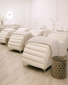 there are many white beds in the room