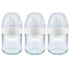 three glass baby bottles with the words nuk on them