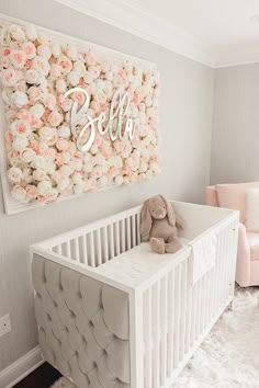 a baby's nursery with pink and white flowers on the wall