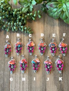 a bunch of different colored beads sitting on top of a wooden table next to plants