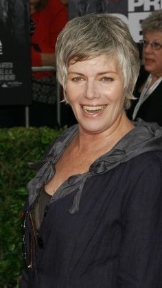 a woman with grey hair smiling at the camera