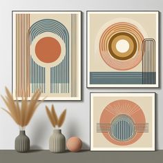 three art prints hanging on the wall next to vases with plants in them and one has an orange circle