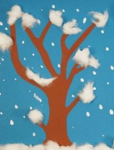 a paper cut out of a tree with snow on the branches and white clouds in the sky