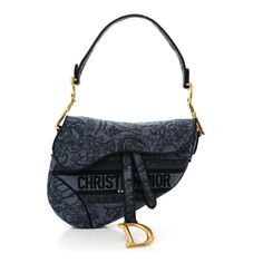 This is an authentic CHRISTIAN DIOR Denim Flowers Embroidered Saddle Bag in Blue. This shoulder bag is crafted of blue denim. It features a denim looping shoulder strap, piping, and hanging straps with a gold D charm. The front flap opens to a matching interior. Luxury Blue Bag With Embroidered Logo, Luxury Blue Bags With Embroidered Logo, Luxury Embroidered Logo Crossbody Bag, Dior Denim, Christian Dior Homme, Flowers Embroidered, Denim Flowers, Saddle Bag, Lady Dior