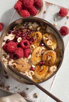 a bowl of oatmeal with bananas and raspberries