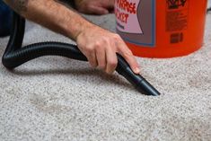 a man is using a vacuum to clean the carpet