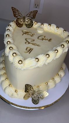 a white cake with gold butterflies on it