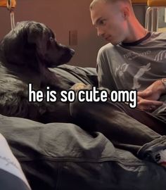 a man laying in bed next to a dog with the caption he is so cute omg