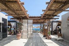 an outdoor area with tables, chairs and potted plants on the side of it