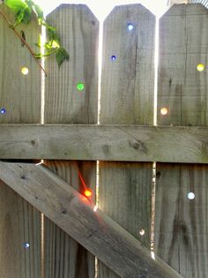 a wooden fence with lights on it and a tree branch in the middle of the fence