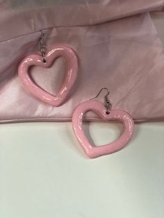 Heart-shaped dangle earrings made from clay. Pink Heart Earrings Aesthetic, Acrylic Laser Cut Earrings, Mini Ceramics, Werewolf Oc, Heart Shape Earrings, Band Au, Trilogy Tour, Diy Pottery Painting, Pink Heart Earrings