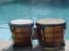 two wooden drums sitting next to a swimming pool