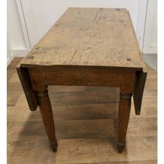 an old wooden table sitting on top of a hard wood floor