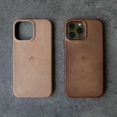 two iphone cases sitting next to each other on top of a gray carpeted floor