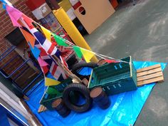 there is a toy truck and some flags on the blue tarp in front of a building