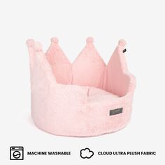 a pink dog bed with a crown on it