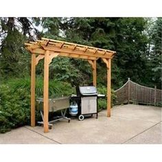 an outdoor bbq and grill area with trees in the background