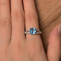 It is a lab created Swiss blue topaz ring. The main stone is 8mm*8mm cushion cut. weight about 2.93 carats. It's stunning and lovely! The basic metal is sterling silver and plated with rhodium. To change the metal to a solid gold (white/rose) or platinum is also available, please ask for a quotation if you want. You can also go to my shop Home for more elegant rings: https://www.etsy.com/shop/godjewelry?ref=hdr_shop_menu Customization is always welcome and please feel free to contact with me if Cushion Cut Topaz Jewelry With Center Stone, Fine Jewelry Cushion Cut Topaz Ring With Center Stone, Cushion Cut Topaz Ring Fine Jewelry, Fine Jewelry Cushion Cut Topaz Ring For Anniversary, Cushion Cut Blue Topaz Rings With Diamond Accents, Blue Cushion Cut Topaz Promise Ring, Cushion Cut Blue Topaz Jewelry With Center Stone, Silver Cushion Cut Topaz Ring With Diamond Accents, White Gold Topaz Ring With Cushion Cut Center Stone