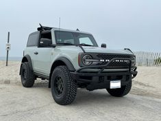 a white truck parked on top of a sandy beach