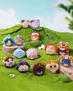 a group of animal figurines sitting on top of a lush green hill covered in grass