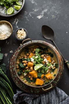 a bowl filled with beans and greens next to other foods on a black counter top