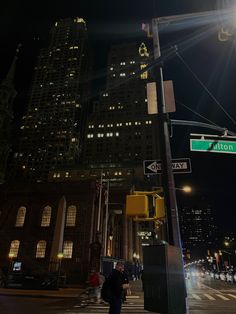 a street sign that is on the side of a pole at an intersection with buildings in the background