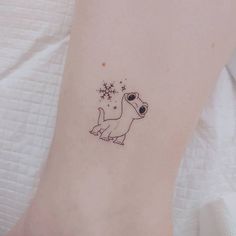 a small tattoo on the ankle of a woman's foot with an image of a dog