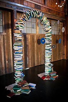 an arch made out of books in front of a wooden wall