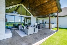 an outdoor living area with patio furniture and large windows on the side of the house