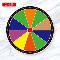 a colorful wheel of fortune sitting on top of a white marble surface with chinese writing