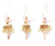 three ballerina ornaments hanging from strings on a white background, one in gold and the other in pink