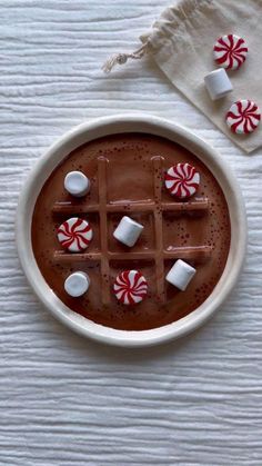 hot chocolate with marshmallows and peppermints in a bowl on a table