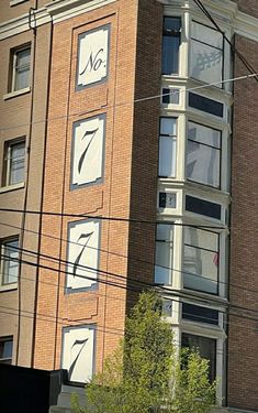 a tall brick building with two clocks on it's sides and the number seven