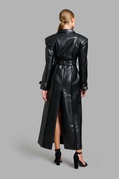 Black faux leather classy trench coat with wide shoulders and shoulder pads. Sleeves are decorated with belts, belt loops, and exserted stitches. Free worldwide shipping! Delivery time: 6-8 days Designer Formal Outerwear With Belt, Fitted Leather Jacket With Belted Cuffs, Designer Belted Outerwear For Office, Luxury Belted Outerwear For Formal Occasions, Luxury Formal Outerwear With Belt, Luxury Office Outerwear With Belt Loops, Black Leather Outerwear With Belted Cuffs, Luxury Belted Leather Jacket For Business, Formal Belted Leather Jacket