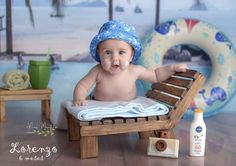 a baby sitting in a chair with a hat on it's head, next to a bottle of sunscreen