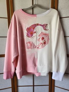 The Koi cape hoodie is now also available as super comfy oversize sweater in White/Light Pink. The Fabric is a very soft, warm Jersey (80% Cotton, 20% Polyester) The inside is fleecy to keep you warm and cozy. Check pictures for measurements. The Koi Carps are hand printed and have a metallic look. Hand wash is recommended, but it is pre washed because the fabric is hand dyed, so it should be fine up to 40o machine wash for the print and to not shrink. Oversized Harajuku Sweatshirt For Fall, Pink Oversized Harajuku Sweatshirt, Oversized Pink Harajuku Sweatshirt, Oversized Pink Harajuku Style Sweatshirt, Oversized Harajuku Sweatshirt For Spring, White Harajuku Hoodie Top, White Harajuku Long Sleeve Hoodie, Harajuku White Hoodie Tops, White Harajuku Style Hoodie Top