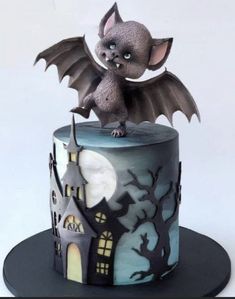 a cake with a bat on top of it and a castle in the back ground