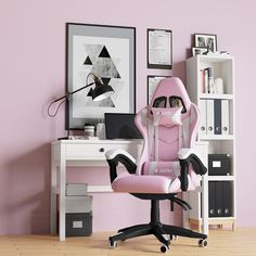 a pink office chair sits in front of a desk with a computer monitor and bookshelf