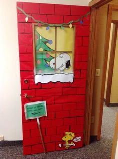 a door decorated to look like a christmas tree with a snoopy window on it