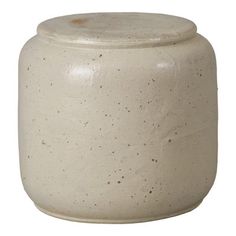 a white ceramic jar with speckles on the outside and inside, sitting on a white surface