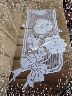 the table is covered in white lace and has flowers on it, with pearls scattered all over