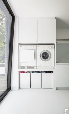 a washer and dryer in a white room next to a window with open doors