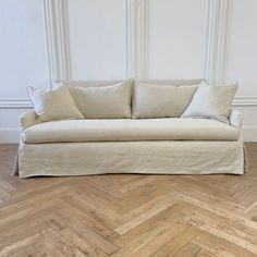 a white couch sitting on top of a wooden floor