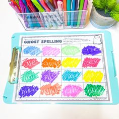 colorful crayons and markers are sitting on a table next to a clipboard with the words ghost spelling