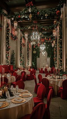 a dining room with red chairs and tables covered in white tablecloths, decorated for christmas