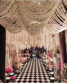 a black and white checkerboard floor with chandeliers hanging from the ceiling