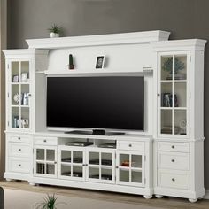 a white entertainment center with glass doors and shelves