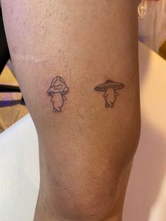 two small tattoos on the legs of someone's leg, one with an umbrella